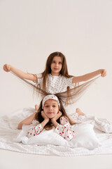 Pajama party. Happy children's laughter. Happy girls laughing, lying next to each other. Concept of childhood, leisure, friendship. happiness. Cheerful good morning. Vertical.