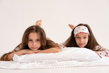 Pajama party. Happy children's laughter. Happy girls laughing, lying next to each other. Concept of childhood, leisure, friendship. happiness. Cheerful good morning!