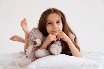 Happy girl spilled on fresh morning. Morning calm on white bed linen. Good morning concept. Good sleep and healthy lifestyle.