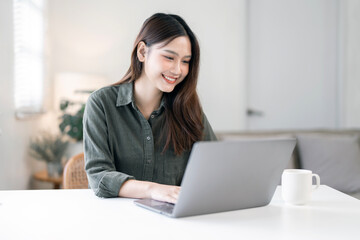 Young asian woman using laptop computer work from home