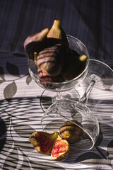 Juicy figs in a ceramic bowl on a wooden table - still life with natural light