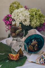 Juicy figs in a ceramic bowl on a wooden table - still life with natural light
