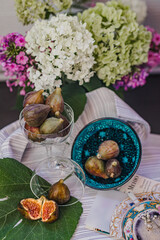 Juicy figs in a ceramic bowl on a wooden table - still life with natural light