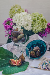 Juicy figs in a ceramic bowl on a wooden table - still life with natural light