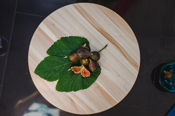 Juicy figs in a ceramic bowl on a wooden table - still life with natural light