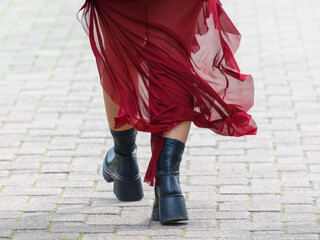 A woman in a red dress is walking down a brick walkway