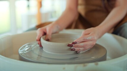Close up hands of artisan's shaping creating clay bowl in pottery wheel in studio. Pottery art and creativity, handmade ceramic art, and craftsmanship in traditional ceramic workshop