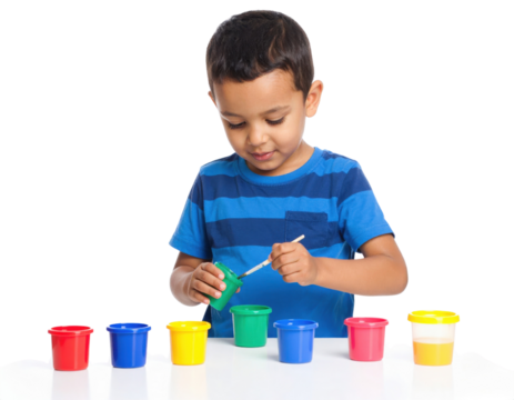 A young boy in a blue striped shirt is painting with colorful paint pots, concentrating on his creative activity.