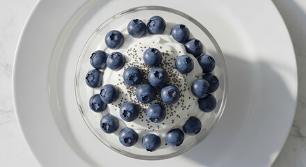 Yogurt with fresh blueberries and chia seeds in a clear bowl, a perfect image of a healthy and delicious breakfast.