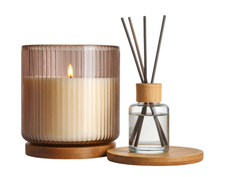 A lit cream-colored candle in a ribbed glass holder sits next to a reed diffuser with wooden sticks in a clear liquid, both placed on round wooden bases.