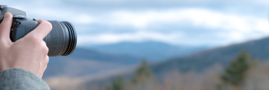Person is using a camera to capture views of distant mountain range during World Photography Day festivities