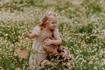 A boy with hearing aids and his little sister gather daisies in a sunlit field, sharing a joyful...