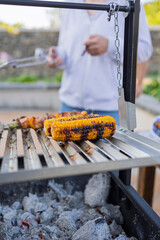 Grilling corn on the cob and chicken skewers on a barbecue grill
