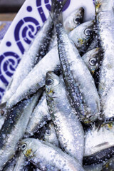 Fresh sardines sprinkled with coarse salt on a decorative plate