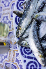 Fresh sardines sprinkled with sea salt on decorative plate