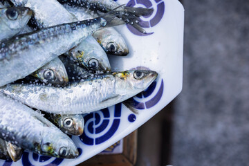 Fresh sardines sprinkled with coarse salt on decorative plate