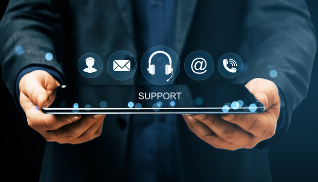 Businessman holding digital tablet with virtual support icons representing online customer service and communication solutions interface.