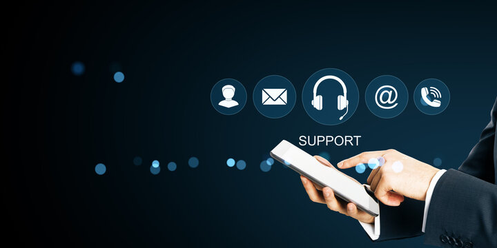 Businessman using smartphone for online support services with communication icons on dark tech background illustrating digital help concept.