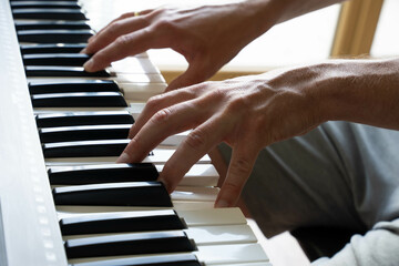 Close-up view of hands playing piano indoors expressing focus, precision, and artistic engagement