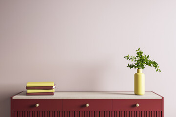 Modern beige wall interior with red wooden dresser, yellow vase with green plant, and stacked books...