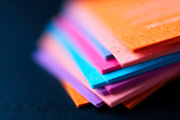 Stack of orange and blue flyers fanned out on dark background modern marketing display