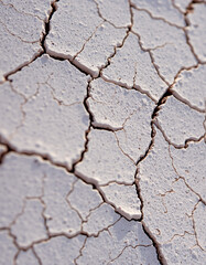 Close-up of cracked, dry, and weathered gray paint surface revealing intricate fissures and textures