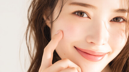 頬に指を当てて笑顔でこちらを見つめる女性のクローズアップ