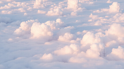 A vast sky filled with fluffy white clouds illuminated by sunlight, creating a serene and peaceful atmosphere with soft textures and varying shades of blue and white