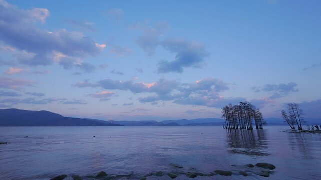 Tranquil Lakeside Sunset with Soft Blue-Pink Sky