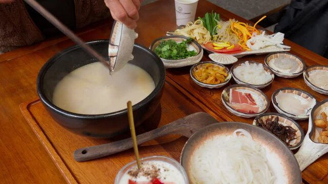 A beautifully arranged presentation of all ingredients for Yunnan&rsquo;s iconic Crossing-the-Bridge Noodles, including raw meats, vegetables, noodles, and toppings