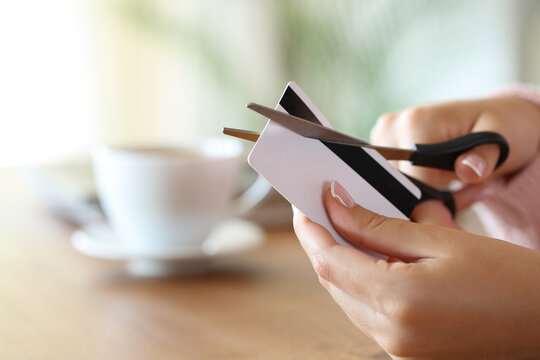 Woman hand destroying credit card cutting with scissors