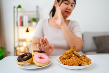 A woman refuses to eat fast food, fried chicken and donuts on her plate to lose weight and healthy