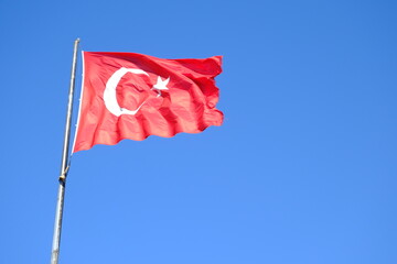 The Turkish Flag waving on the flagpole. The red Turkish Flag with star and crescent waves in the...