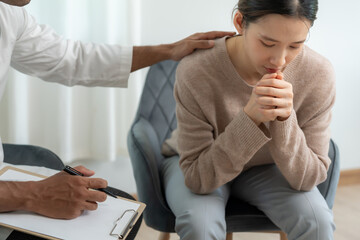 psychiatrist holds shoulders while discussing life and family issues. doctor encourages and empathy...