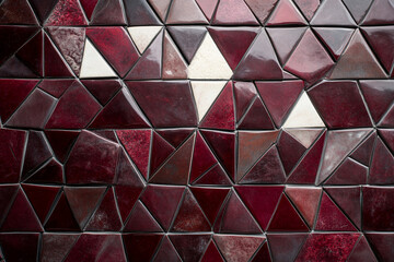 Geometric pattern design in burgundy and ivory tones creates a captivating visual rhythm on a textured surface