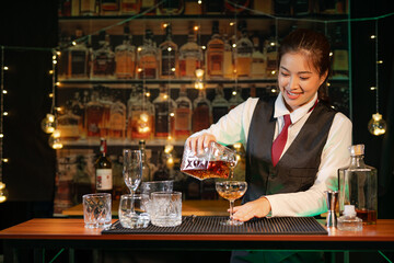 Professional female bartender preparing alcoholic drinks in a bar