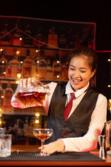  Professional female bartender preparing alcoholic drinks in a bar