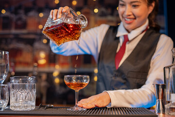 Professional female bartender preparing alcoholic drinks in a bar