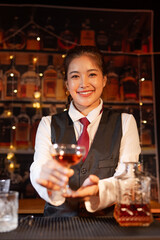 Professional female bartender preparing alcoholic drinks in a bar