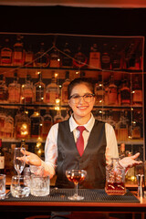 Professional female bartender preparing alcoholic drinks in a bar