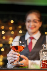 Professional female bartender preparing alcoholic drinks in a bar