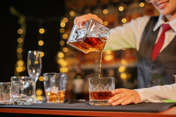 Professional female bartender preparing alcoholic drinks in a bar