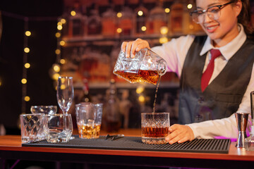  Professional female bartender preparing alcoholic drinks in a bar