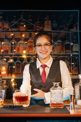 Professional female bartender preparing alcoholic drinks in a bar