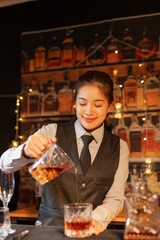 Professional female bartender preparing alcoholic drinks in a bar