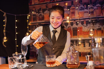 Professional female bartender preparing alcoholic drinks in a bar