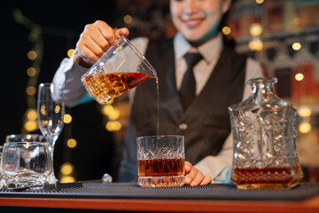 Professional female bartender preparing alcoholic drinks in a bar