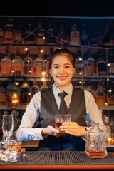 Professional female bartender preparing alcoholic drinks in a bar