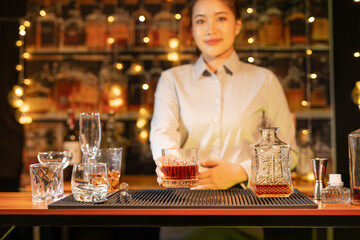 Professional female bartender preparing alcoholic drinks in a bar