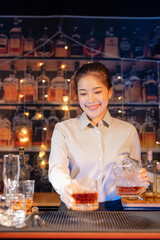  Professional female bartender preparing alcoholic drinks in a bar